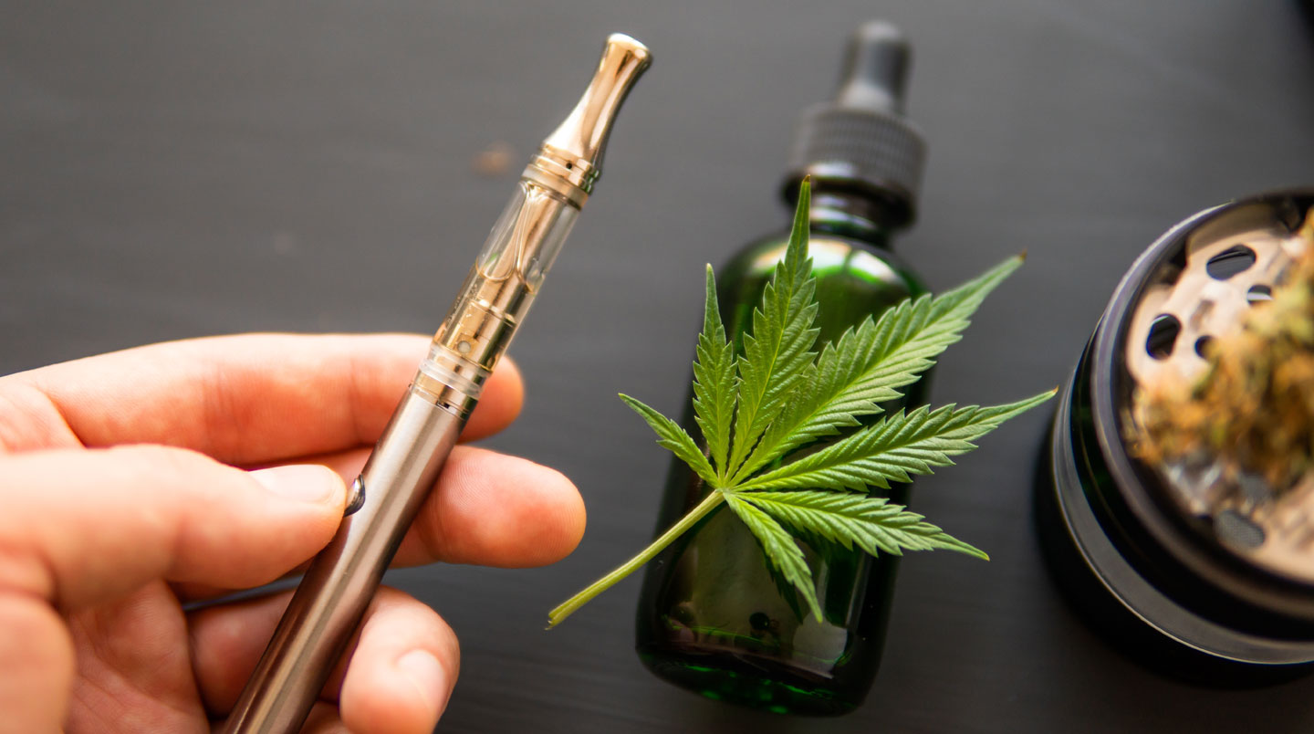 Trois produits CBD disposés sur fond blanc : flacon d'huile sublinguale avec pipette, bocal transparent de fleurs de chanvre séchées, et cartouche de vaporisation moderne, composition minimaliste